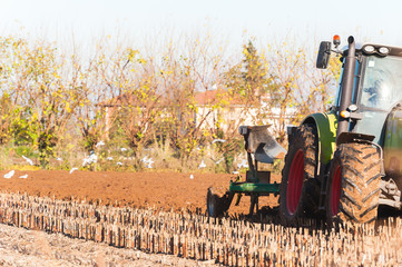 Obraz premium Tractor with plow. Plowing a field of corn.