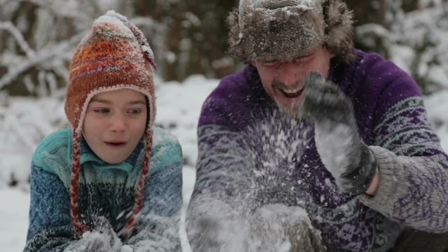 Portrait of a father and sons playing snowballs. Man and child in the park in winter.
