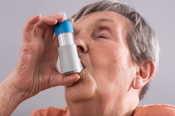 Senior woman with asthma inhaler