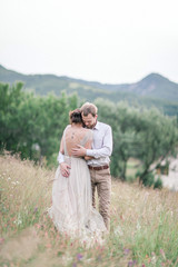 Couple in wedding attire with a bouquet of flowers and greenery