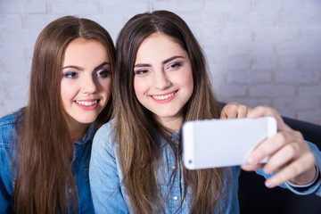 two beautiful women taking selfie photo with smart phone