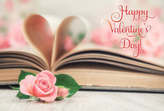 Old book pages curved into a heart and roses, text Happy Valenti
