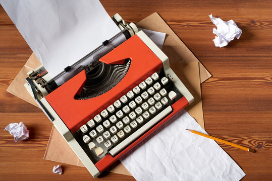 Red vintage typewriter with white blank paper sheet