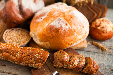 Fresh bread and wheat on the old wooden table