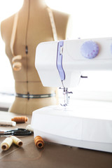 Tailor workshop with white sewing machine, fashion dummy, detail