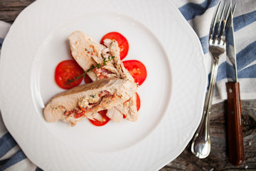 Chicken with cheese Dorblu and tomatoes, served rosemary on vint