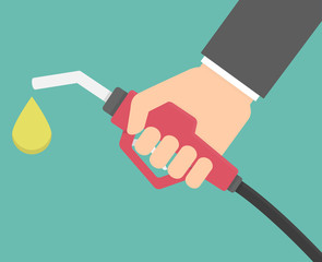 Hand holding a red gas pump with an oil drop