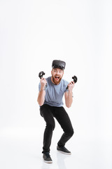 Young screaming happy man wearing virtual reality device