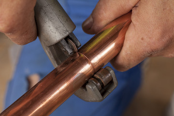 cutting copper pipes with pipe cutter
