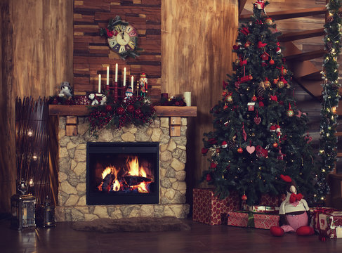 Beautiful holiday decorated room with Christmas tree, fireplace at night. Led lighting, cozy home scene. Nobody there.