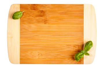 Empty smooth cutting board. Wooden kitchen board and basil leafs.