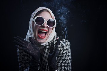 Young retro vintage woman smoking a cigarette and laughing, lady with style