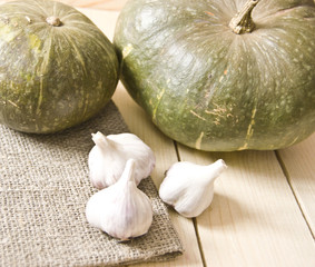 Obraz premium fresh garlic and fresh pumpkin on a wooden table