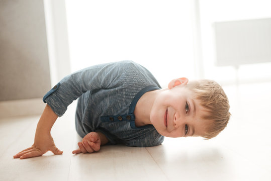 Little boy lies on the floor while look at camera.