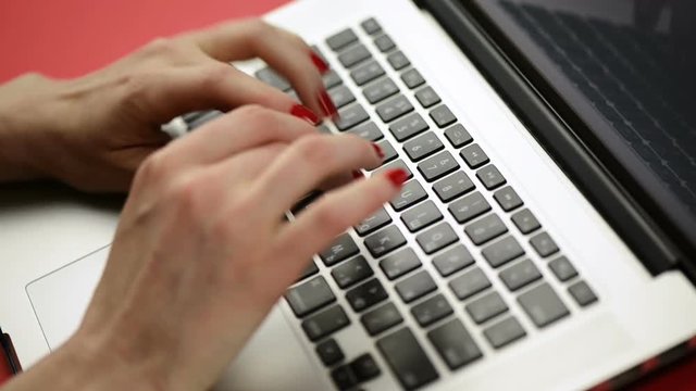 Woman's hands typing on laptop