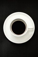 Perspectiva de un café en taza blanca sobre fondo negro