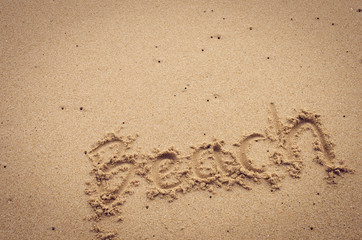 Beach words hand writing on sand beach texture abstract background.