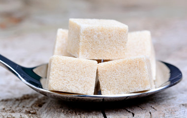 Silver spoon with beige sugar cubes