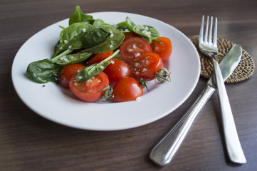 Salad of spinach and tomatoes with salt and olive oil