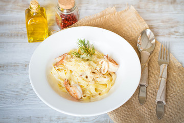 Spaghetti with tomato paste, hot Chili peppers and olive oil. On rustic background. Top view