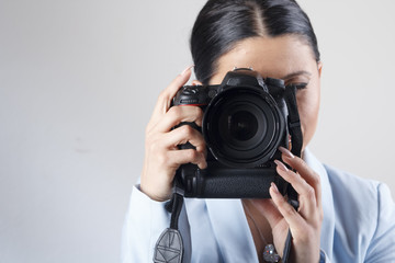 Young businesswoman holding a professional dslr camera