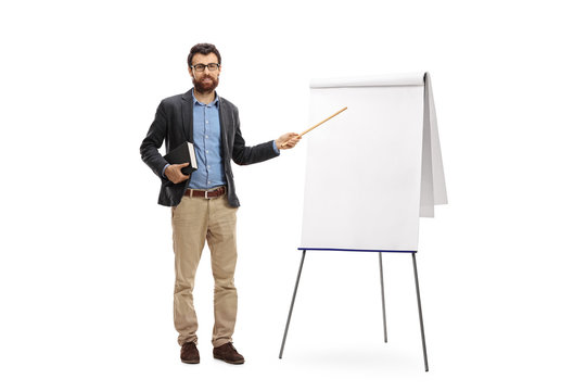 Teacher Holding A Book And Pointing With A Wand At A Blank Presentation Board