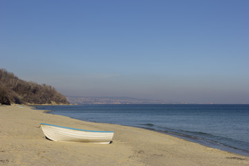 Day landscape of lonely boat on the beach