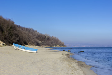 Fototapeta na wymiar Day landscape of lonely boat on the beach