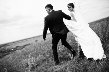 The lovely couple in love running along field