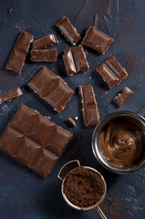 Broken chocolate bar and cacao.