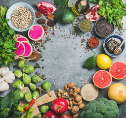 Clean eating concept over grey concrete background, top view, copy space. Variety of vegetables, fruit, seeds, cereal, bean, spices, superfood, herbs, condiment for vegan, raw diet or gluten free diet