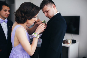 The bridesmaid keeps a buttonhole for groom