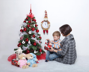 mother with her young son on a white background in a Christmas tree