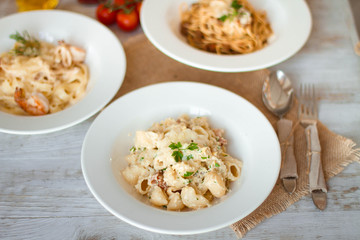 Spaghetti with tomato paste, hot Chili peppers and olive oil. On rustic background. Top view