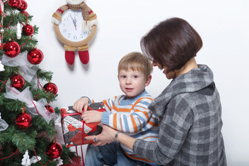 mother with her young son on a white background in a Christmas tree