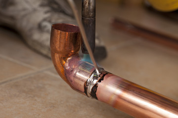 soldering copper pipes with tin and torsh - obrazy, fototapety, plakaty
