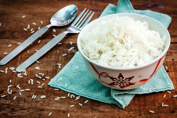 Rice in a bowl on wooden background
