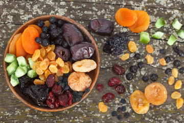 Mix of dried fruits on a dark wood background. Top view. 