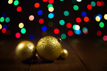 Christmas balls on wooden table over colorful bokeh background