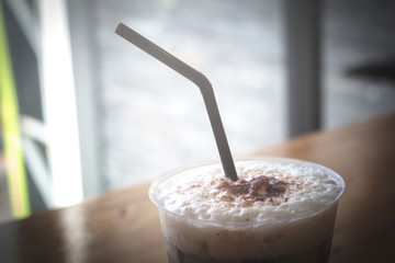 Ice coffee in a glass on the wooden table