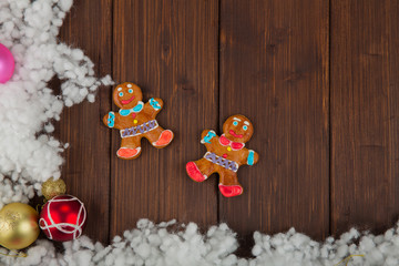 Colored christmas balls and gingerbread man decoration on wood