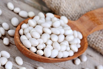 White beans in a wooden spoon