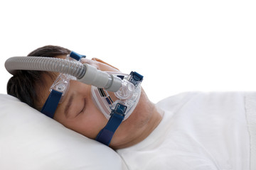Sleep apnea therapy, Man sleeping in bed wearing CPAP mask.Healthy senior man sleeping deeply, happy on his back without snoring,isolated white background
