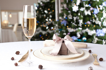 Christmas gifts on the beautiful table with Christmas tree on ba