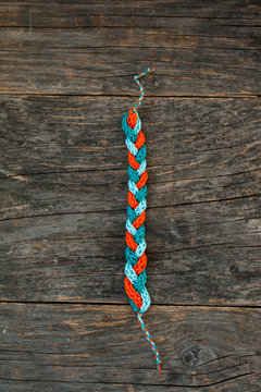 Handmade knitted bracelet on a wooden background