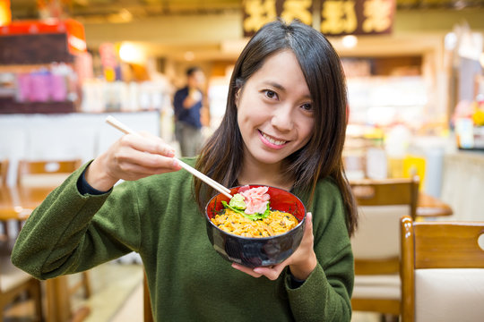 Woman Having Urchin Rice Bowl In Japanese Restaurant