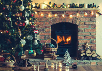 Christmas decorations in the basket in front of the fireplace with candles and baubles, selective...