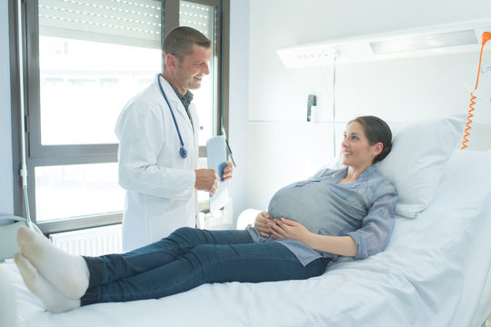 doctor and pregnant patient talking in hospital