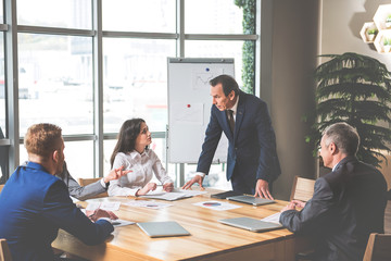 Serious employer is talking to his employees