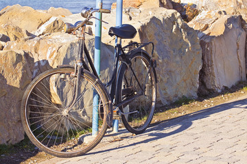Fototapeta na wymiar Old rusty bicycle parked against a rock wall
